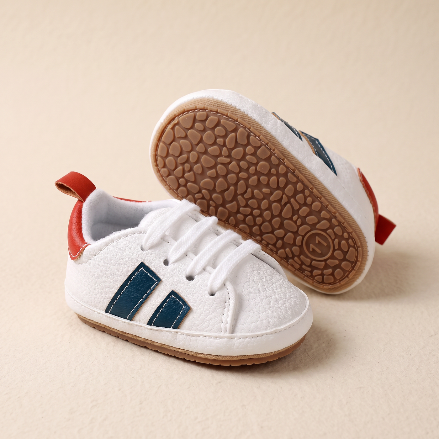 Zapatos de piel de primeros pasos sobre fondo hueso