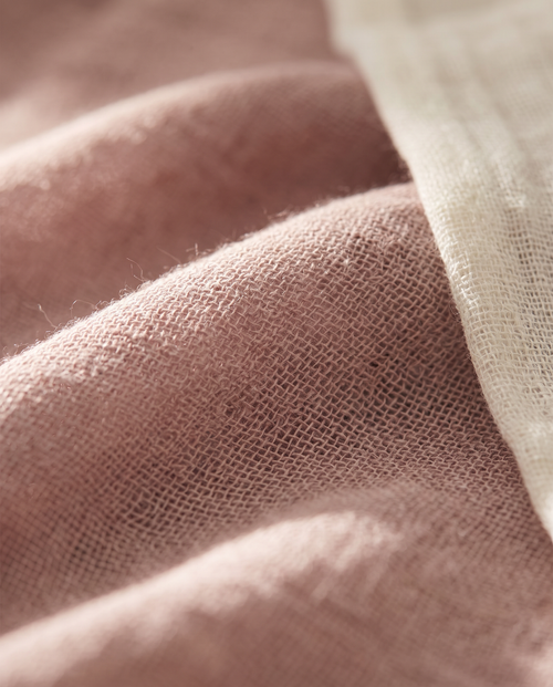 Detalle macro del tejido de gasa de bambú en rosa empolvado