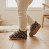 Un bebé camina con los zapatos de leopardo