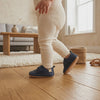 Un bebé camina con los zapatos marino con velcro