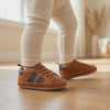 Un bebé camina con los zapatos caramelo con cordones