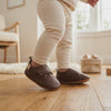 Un bebé camina con los zapatos marrón con velcro